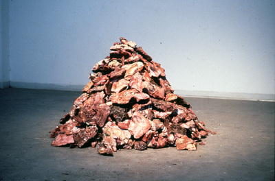 "Flesh Pile"  Plaster, pictures torn from porn, acrylic paint, earth.  33"x50" diameter  1990s
